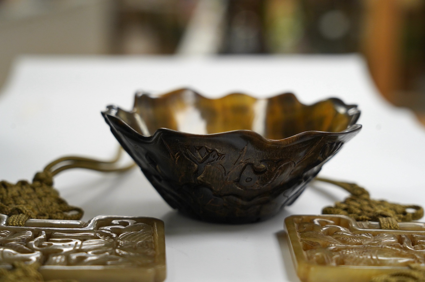 A pair of Chinese carved plaques of fish, 8.5 x 6.5cm, and a horn cup, 4.5cm. Condition - good